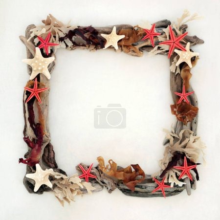 Starfish seashells, seaweed and driftwood heart shape wreath abstract design on hemp paper background. Creative natural square shape nature frame composition.