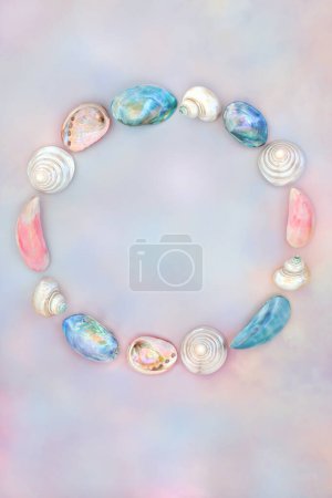 Mother of pearl and sea shell wreath decoration on rainbow sky background. Seaside summer art design for logo or greeting card.
