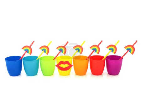 Téléchargez les photos : Tasses à boire arc-en-ciel avec des lèvres et des pailles de papier respectueux de l'environnement sur fond blanc. Design abstrait coloré avec trans LGBT et thème écologique - en image libre de droit