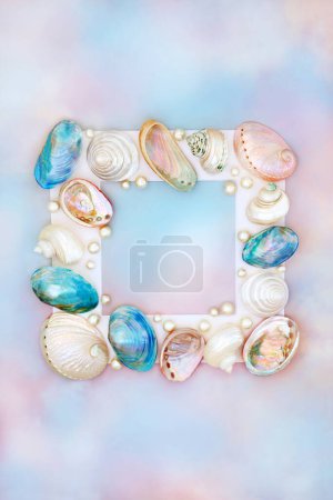 Shell and pearl abstract background frame on rainbow sky  with a variety of mother of pearl shells. Natural summer nature design, beach and seaside art.