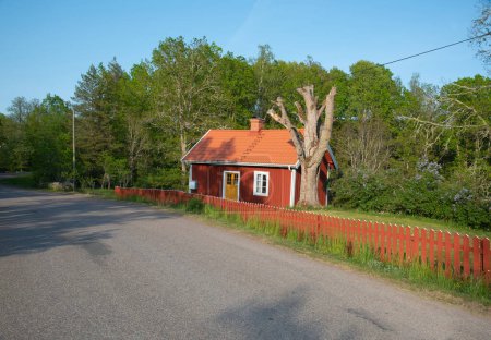 Maison traditionnelle en bois rouge dans le sud-est peu peuplé de la Suède dans le district de Kalmar. La photo a été prise lors de l'un des premiers jours de l'été.