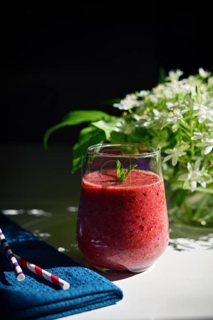 Photo for Tasty Fresh Berry Smoothie, Paper Straws and Star of Bethlehem Flowers in vase - Royalty Free Image