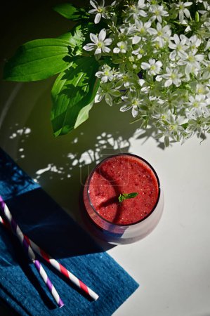 Photo for Tasty Fresh Berry Smoothie, Paper Straws and Star of Bethlehem Flowers in vase - Royalty Free Image