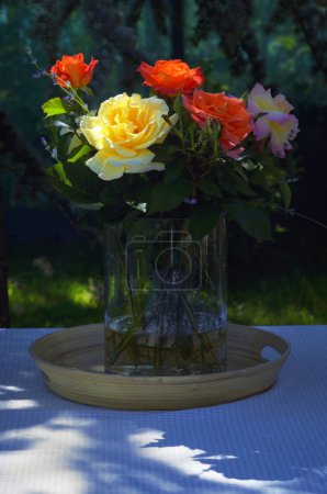 Photo for Roses in Vase on Table in Summer Garden - Royalty Free Image