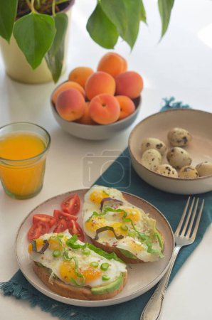 Photo for Fried Quail eggs, Avocado, Parmesan and Cherry Tomatoes on Table - Royalty Free Image