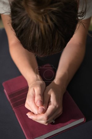 Téléchargez les photos : Gros plan de femmes chrétiennes mains pliées sur la Sainte Bible sont la prière et l'adoration - en image libre de droit