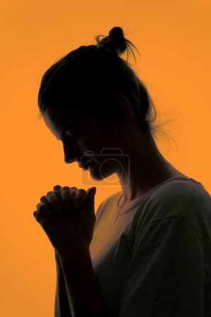 Photo for Closeup Profile Of A Woman Praying In Silhouette Isolated in Studio - Royalty Free Image