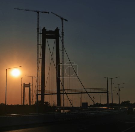 Téléchargez les photos : Slhouette du pont routier suspendu entre Braila et Tulcea Villes en Roumanie - en image libre de droit
