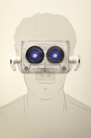 Téléchargez les photos : Cassette audio abstraite sur Man Face. Homme Écouter de la musique avec écouteurs - en image libre de droit