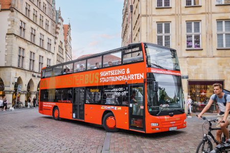 Photo for 25 July 2022, Munster, Germany: Hop on Hop off touris excursion double decker bus at the old town street - Royalty Free Image