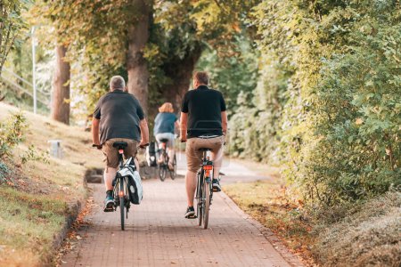 Foto de 25 de julio de 2022, Munster, Alemania: Los ciclistas recorren el carril bici en el parque de la ciudad - Imagen libre de derechos
