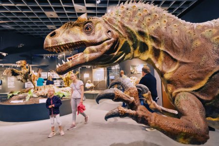 Foto de 26 de julio de 2022, Munster Natural History Museum, Alemania: Familia con niños visitando la exposición de aterradoras maquetas de dinosaurios del período Jurásico y Cretácico - Imagen libre de derechos