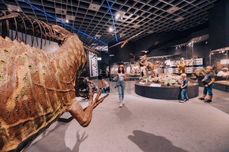 Foto de 26 de julio de 2022, Munster Natural History Museum, Alemania: Familia con niños visitando la exposición de aterradoras maquetas de dinosaurios del período Jurásico y Cretácico - Imagen libre de derechos