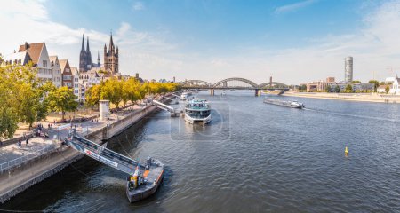 Foto de 29 Julio 2022, Colonia, Alemania: Vista panorámica de la ciudad de Koln, el río Rin, puentes y varios transbordadores y barcos en el muelle. - Imagen libre de derechos