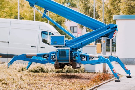 Foto de Grúa telescópica industrial no tripulada de pie sobre patas de soporte hidráulico como una araña en una obra de construcción - Imagen libre de derechos