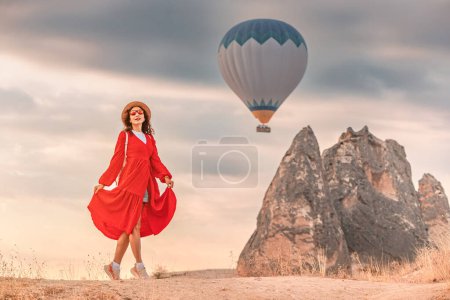 A lone figure in a pretty dress watched the air balloons ascend in Cappadocia, Turkey. Her dark hair lightly blew in the breeze, and a look of wonder shone in her eyes.