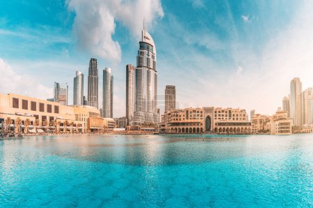 Téléchargez les photos : Étang d'eau près de l'entrée du Dubai Mall et sur un remblai de promenade avec des gratte-ciel en arrière-plan - en image libre de droit