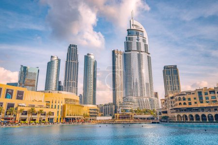 Téléchargez les photos : 18 janvier 2023, Dubaï, Émirats arabes unis : Étang près de l'entrée du centre commercial Dubai Mall et sur un remblai de promenade avec des gratte-ciel en arrière-plan - en image libre de droit