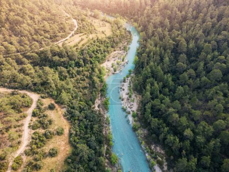 Téléchargez les photos : Vue aérienne d'une rivière sinueuse bleu azur dans un canyon profond entouré d'une forêt sereine - en image libre de droit
