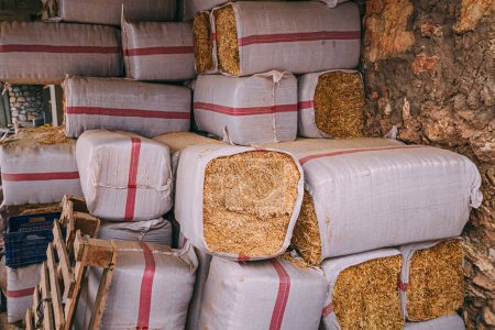 Photo for Organized stacks of packed hay in a barn, carefully prepared to provide feed for livestock. - Royalty Free Image