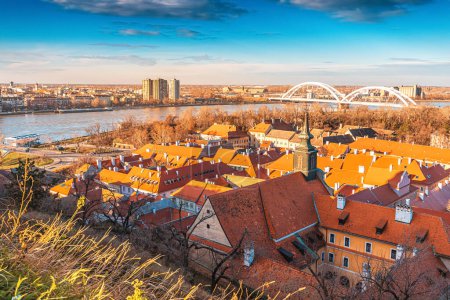 cityscape of Novi Sad from the historic vantage point of Petrovaradin, where ancient towers and charming streets intertwine with the gentle flow of the Danube.