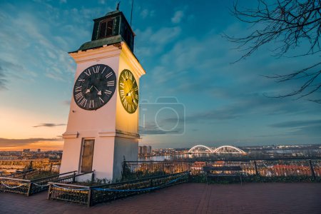 Téléchargez les photos : Soleil se couche sur Novi Sad, l'emblématique tour de l'horloge de la forteresse Petrovaradin se dresse haut, offrant une vue pittoresque de l'histoire et de la culture serbes. - en image libre de droit