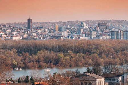 a scenic panoramic observation of Belgrade's cityscape, with its picturesque houses and historic churches lining the banks of the Danube River.