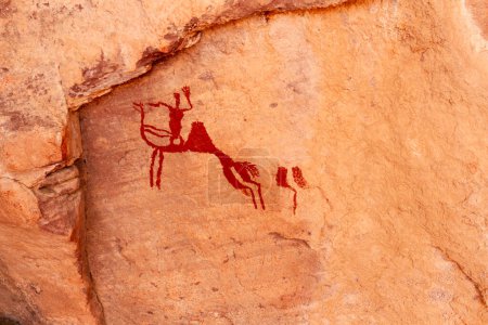Photo for Neolithic rock art. Rock painting of a camel with rider. Tadrart Rouge. Tassili N'Ajjer National Park. Sahara Algerian Desert. Illizi Province, Djanet, Algeria, Africa - Royalty Free Image