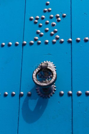 Foto de De cerca. Fragmento de una puerta azul con aldaba redonda de hierro y clavos. Detalle de puerta. Motivo islámico. Chefchaouen, (Chaouen) Marruecos, África - Imagen libre de derechos