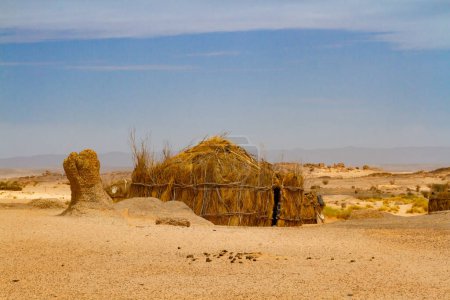 Photo for Tuareg encampment in the desert.   Round hut built in a traditional way reed. South of Algeria, Illizi Province, Djanet, Algeria, Africa - Royalty Free Image
