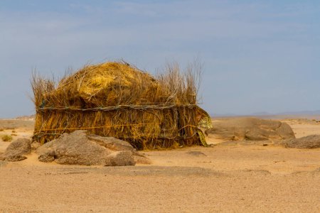 Photo for Tuareg encampment in the desert.   Round hut built in a traditional way reed. South of Algeria, Illizi Province, Djanet, Algeria, Africa - Royalty Free Image