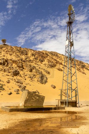 Photo for A well with a windmill pumping water. South of Algeria region of Illizi and Djanet, Sahara, Africa - Royalty Free Image