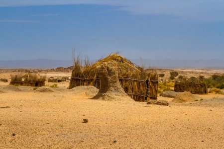 Photo for Tuareg encampment in the desert.   Round huts built in a traditional way reed. South of Algeria, Illizi Province, Djanet, Algeria, Africa - Royalty Free Image