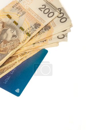 Téléchargez les photos : Grande pile de billets de 200 zlotys polonais et carte bleue sur fond blanc. Synonyme de richesse et d'abondance. - en image libre de droit