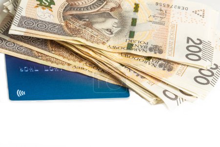 Téléchargez les photos : Grande pile de billets de 200 zlotys polonais et carte bleue sur fond blanc. Synonyme de richesse et d'abondance. - en image libre de droit