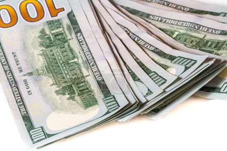 Foto de Una pila de billetes de 100 dólares sobre un fondo blanco. Sinónimo de riqueza y abundancia. - Imagen libre de derechos