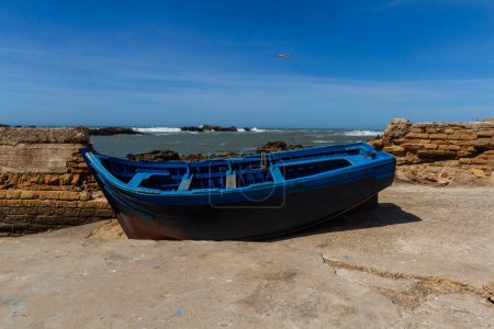 Téléchargez les photos : Bateau de pêche en bois sur le front de mer du vieux port. Essaouira, Maroc, Afrique - en image libre de droit
