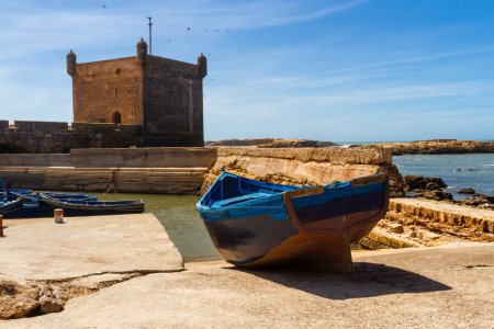 Téléchargez les photos : Bateau de pêche en bois sur le front de mer du vieux port. Fort Essaouira, Maroc, Afrique - en image libre de droit