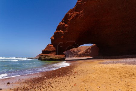 Téléchargez les photos : Spectaculaire arc rouge naturel sur la côte atlantique de l'océan, Legzira (ou Lagzira, ou Gzira) plage. Sidi Ifni, Maroc, Afrique - en image libre de droit