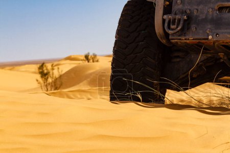 Background.  Close-up. The wheel of an all-terrain vehicle in the desert.