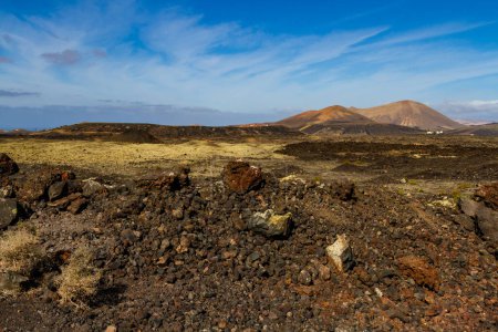 Sendero Haking alrededor de Montana Colorada. "Malpais" - yermo y pedregoso campo de lava Volcán Colorada. Lanzarote, Islas Canarias, España