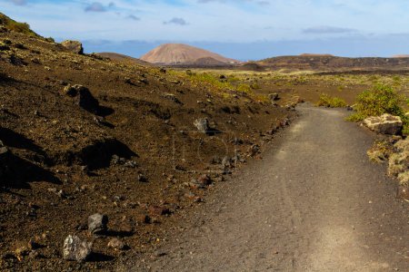 Sendero por Montana Colorada. El camino entre el campo de lava. Isla de Lanzarote, Islas Canarias, España, Europa
