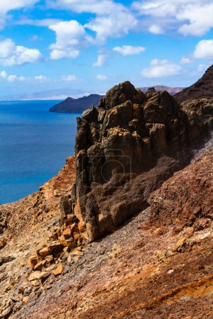 Photo for The magnificent volcanic cliffs of the Atlantic Ocean coast near the lighthouse El Faro de la Entallada, Fuerteventura, Canary Islands, Spain - Royalty Free Image