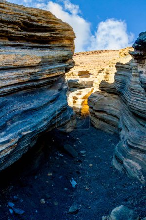 The narrow volcanic gorges and fissures of The Cracks ( Las Grietas ) . The slope of the Montana Blanca volcano. Lanzarote, Canary Islands, Spain