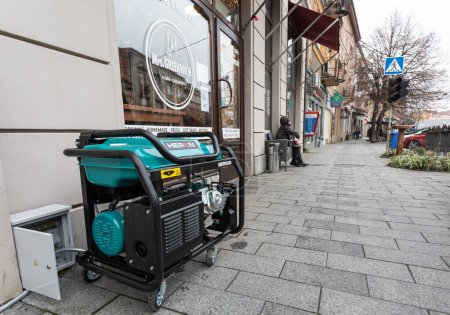 Photo for Blackout in Ukraine. Due to the lack of electricity, cafes and shops are forced to use electricity from portable gasoline generators. Power supply generator placed on street sidewalk - Royalty Free Image