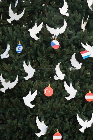 Téléchargez les photos : KYIV, UKRAINE - 22 décembre 2022 : L'arbre de Noël sur la place Sofiyivska à Kiev est décoré de pigeons blancs et de drapeaux de pays qui aident Kiev à faire face aux défis et conséquences liés à la guerre - en image libre de droit