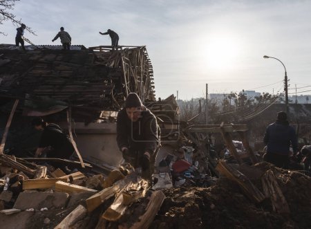 Foto de KYIV, UKRAINE - Jan. 03, 2023: War in Ukraine. Volunteers clear and dismantle debris at the site of a Russian missile attack on December 31 - Imagen libre de derechos