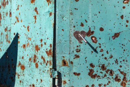 Téléchargez les photos : La surface des portes métalliques est recouverte de marques d'éclats d'obus dans le village de Bogorodichne, région de Donetsk, Ukraine - en image libre de droit