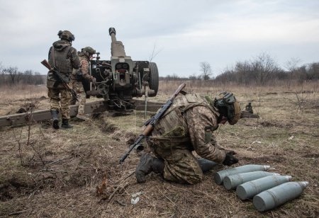 Téléchargez les photos : DONETSK REG., UKRAINE - mars 21, 2023 : Guerre de Russie contre l'Ukraine. Des artilleurs des forces armées ukrainiennes tirant de 122 mm d'obusier D-30 sur des positions russes près de Bahmut - en image libre de droit