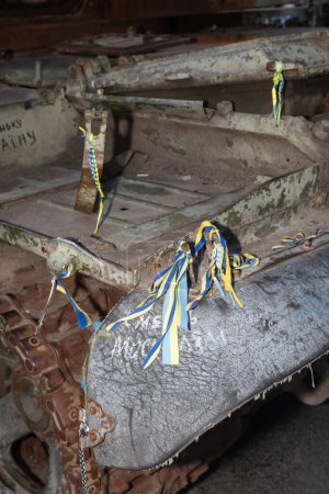 Téléchargez les photos : KYIV, UKRAINE - 24 août 2023 : Fragment d'un char russe brûlé décoré de rubans aux couleurs du drapeau ukrainien et portant l'inscription Mort aux Russes - en image libre de droit